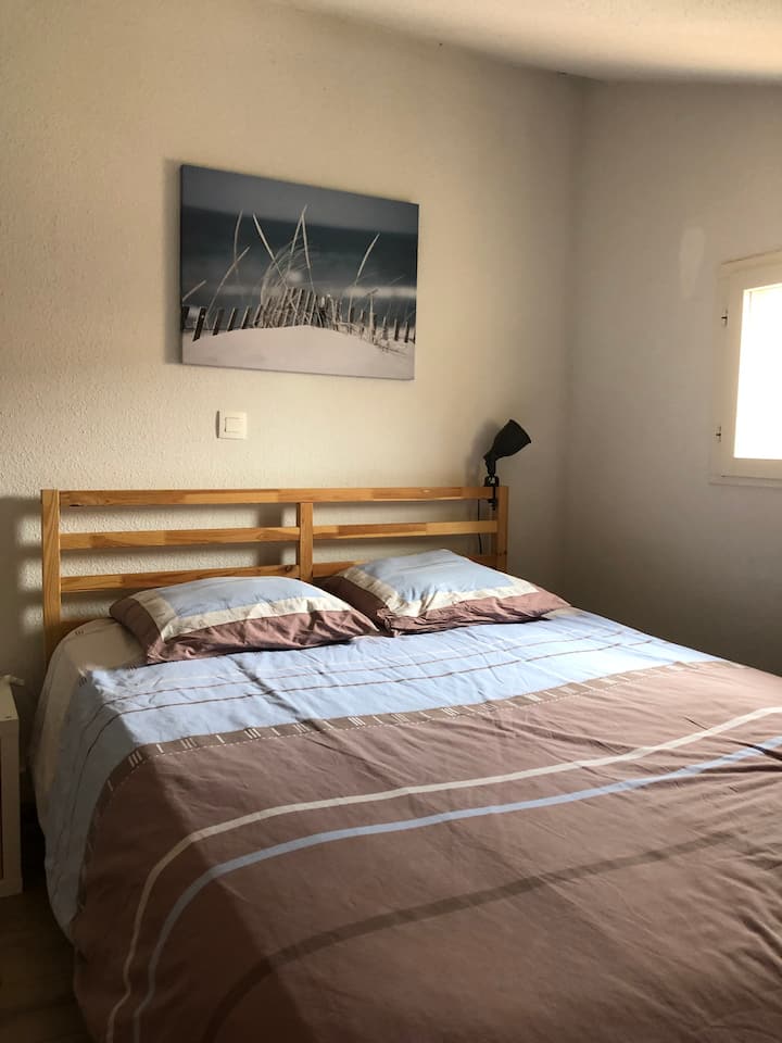 Habitación de arriba en altillo equipada con una cama de matrimonio y una cómoda 