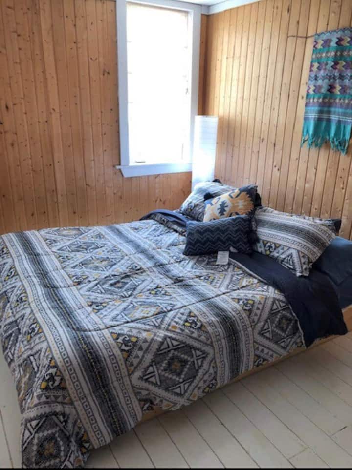 Hlavná spálňa.  Posteľ na plošine je veľká ako menšia manželská posteľ a je nízko pri zemi.