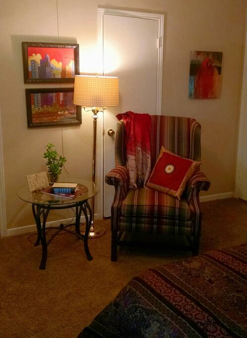 Comfortable reading chair sits opposite the bed.