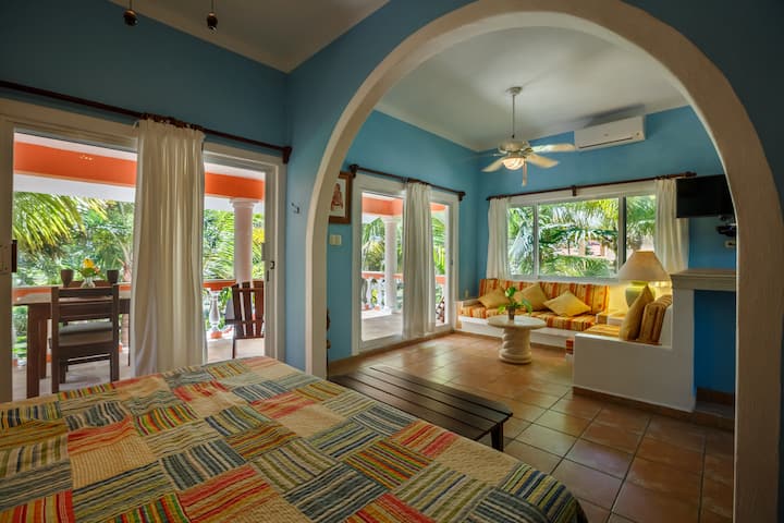 Самостоятелна спалня в къща за гости с изглед към градината и океана
Тази уютна къща за гости разполага с голямо двойно легло, самостоятелна баня и балкон с изглед към градината и морето – идеално за гости, които търсят тихо и уединено място.