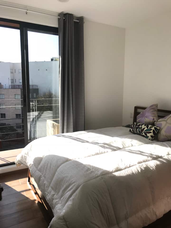 Hlavná spálňa s manželskou posteľou Queen, balkónovými dverami Má šatník, kde môžete zavesiť oblečenie a zásuvky.