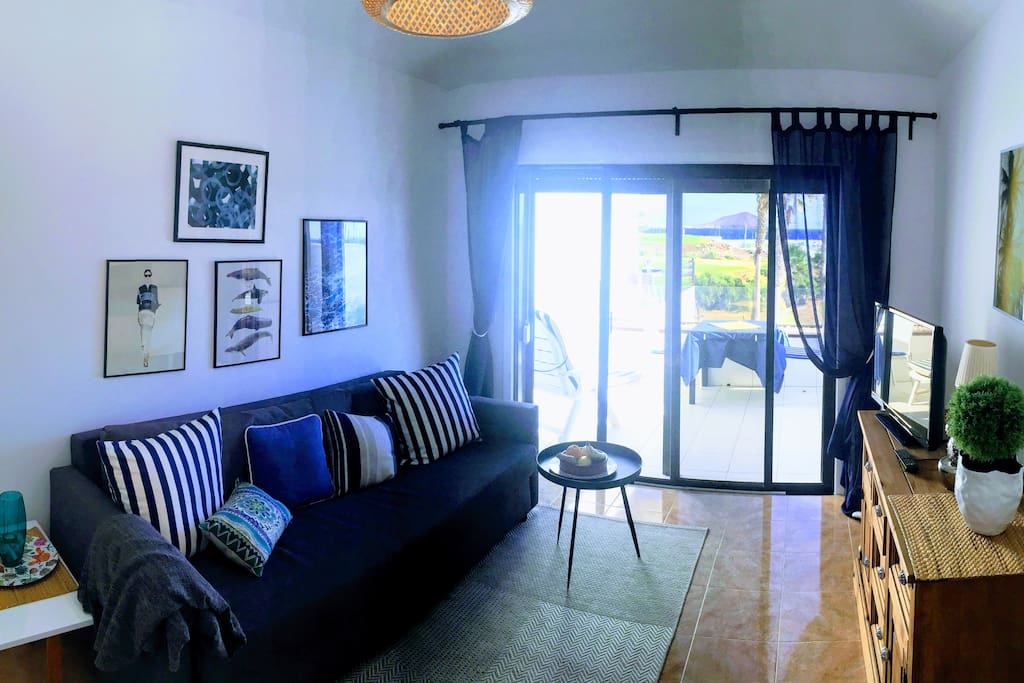 Living room with terrace and stunning view towards the ocean, marina and golf yard