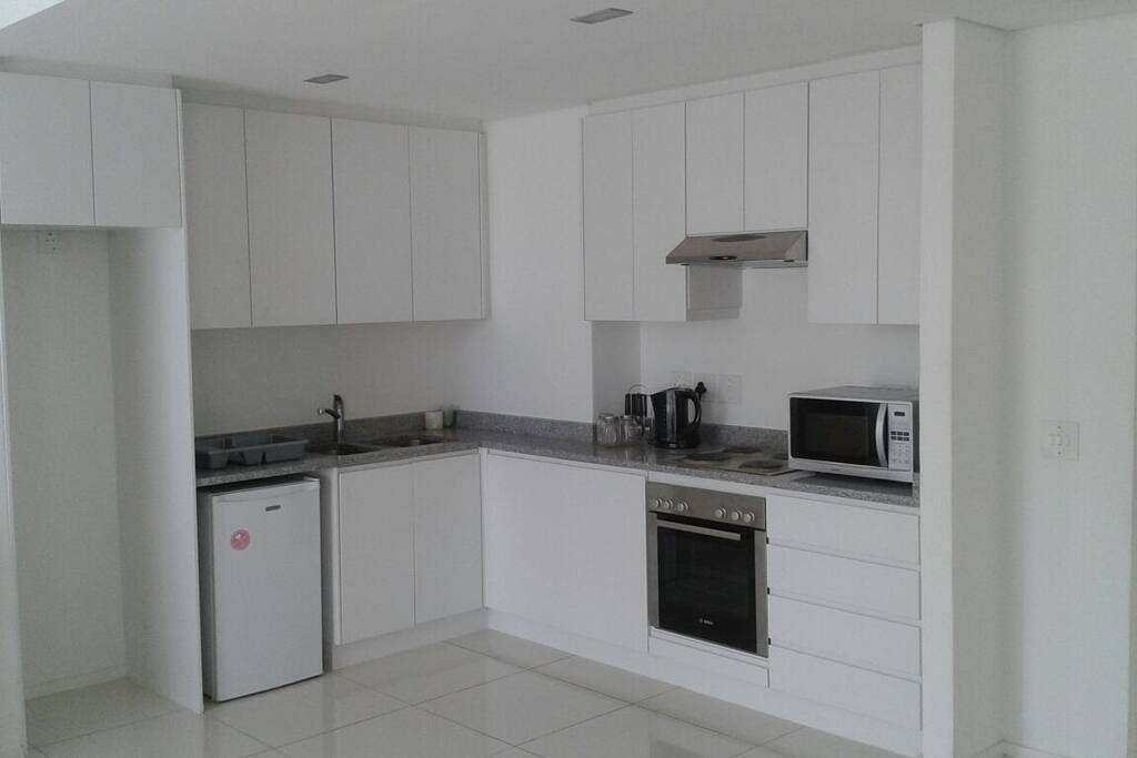 The kitchen is equipped with a microwave, a kettle, a bar fridge, an oven and stove. Cutlery, crockery and a few pieces of cooking equipment are available too. There is also an ironing board and an iron.