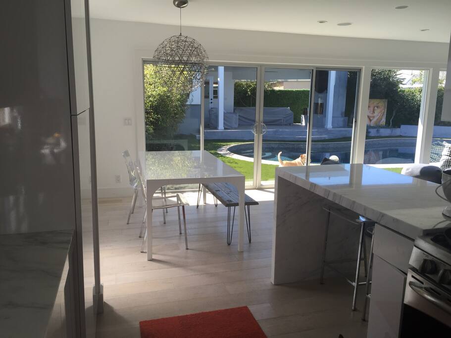 Calcutta marble kitchen overlooks incredible chandelier, living room, pool and cabana with outdoor fireplace! Light 10" whitewashed hardwood floors throughout.