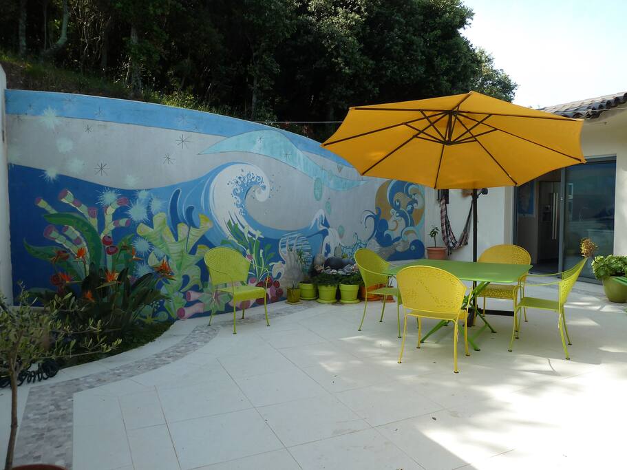 Patio niché sous une petite colline boisée