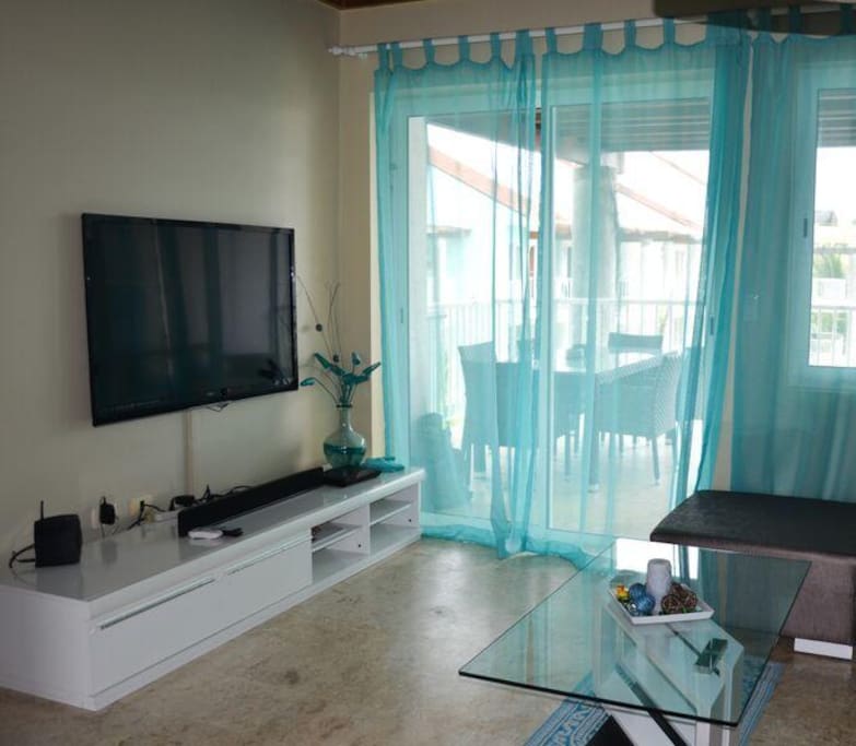 Living quarter with entertainment center and patio doors to spacious covered balcony