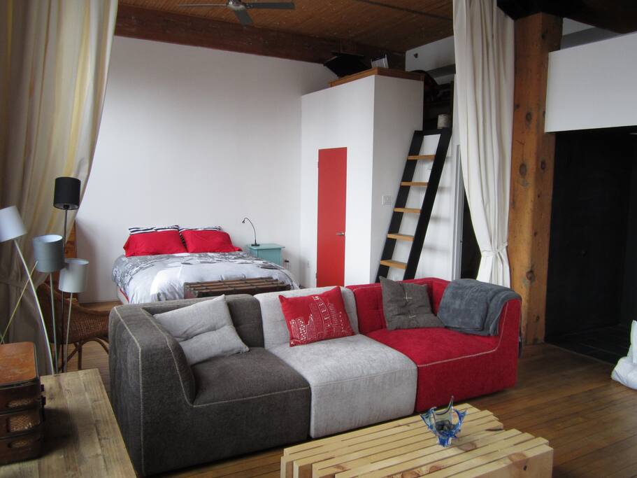 Bedroom, part of living room and ladder going up to mezzanine