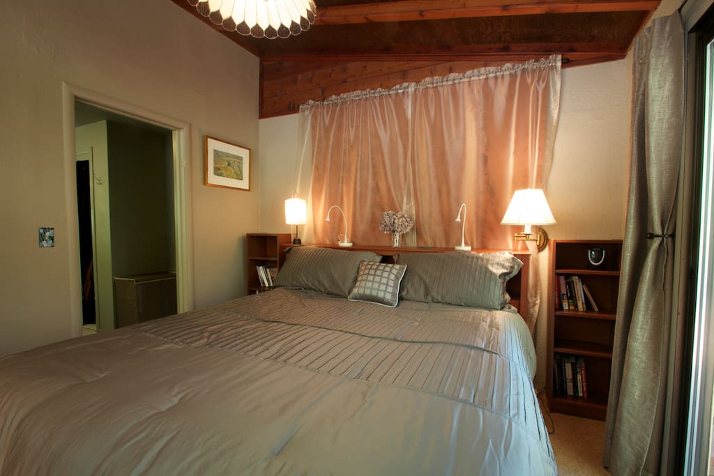 Bedroom with king bed attached dressing room with make up table and hair dryer.