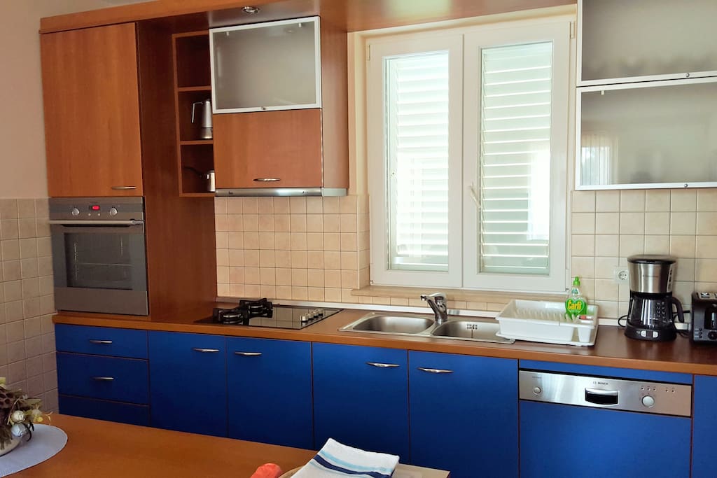 Kitchen with oven, stove, kitchen sink, dishwasher.