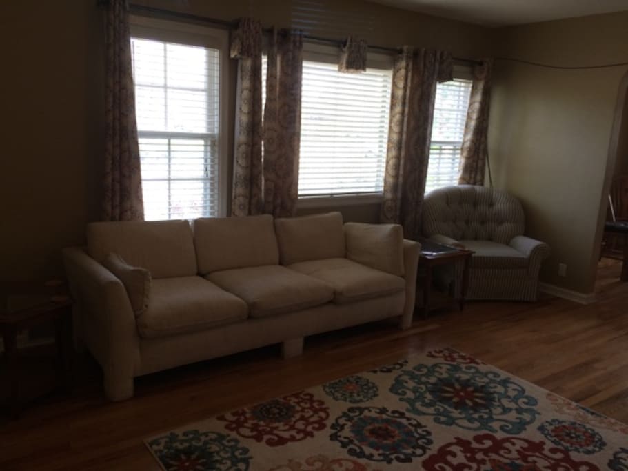Hardwood floors, couch, chair, love seat, flat screen tv.