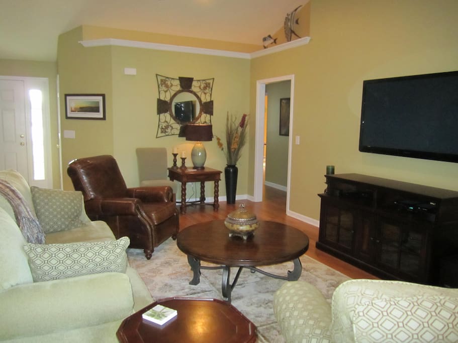 Spacious, comfortable living room area with 60" LED TV, full cable package and surround sound