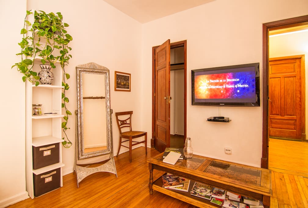 Full length mirror, closet with clothes hangers, 42" screen & Blu-ray/DVD player & center table with books regarding México.