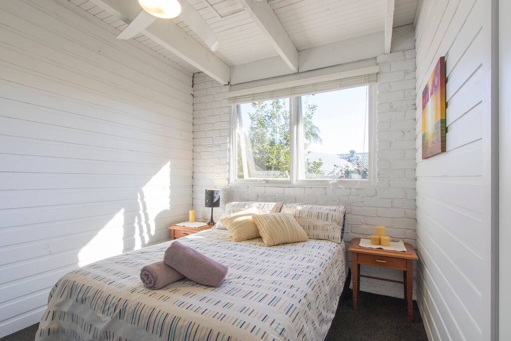 Very clean and cosy carpeted bedroom with lots of natural light through the window.