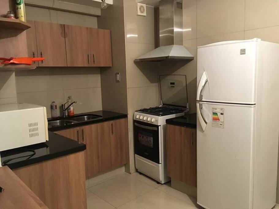 Cocina, con extractor de grasa, microondas, heladera, cocina 4 hornallas, utensilios de cocina, muebles de cocina