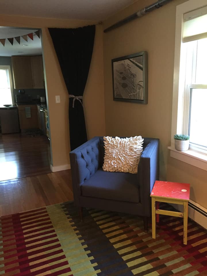 ห้องนั่งเล่นที่มีม่านสีเข้มอ่อนที่เลื่อนข้ามทางเข้าห้อง