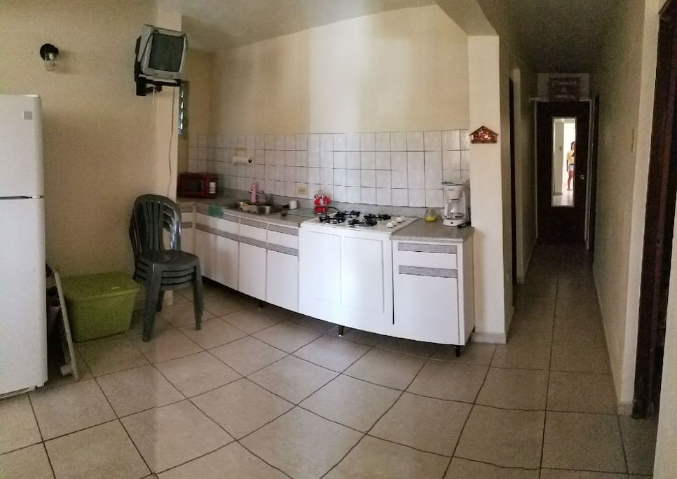 Kitchen area, stove, Fridge, sink and microwave.