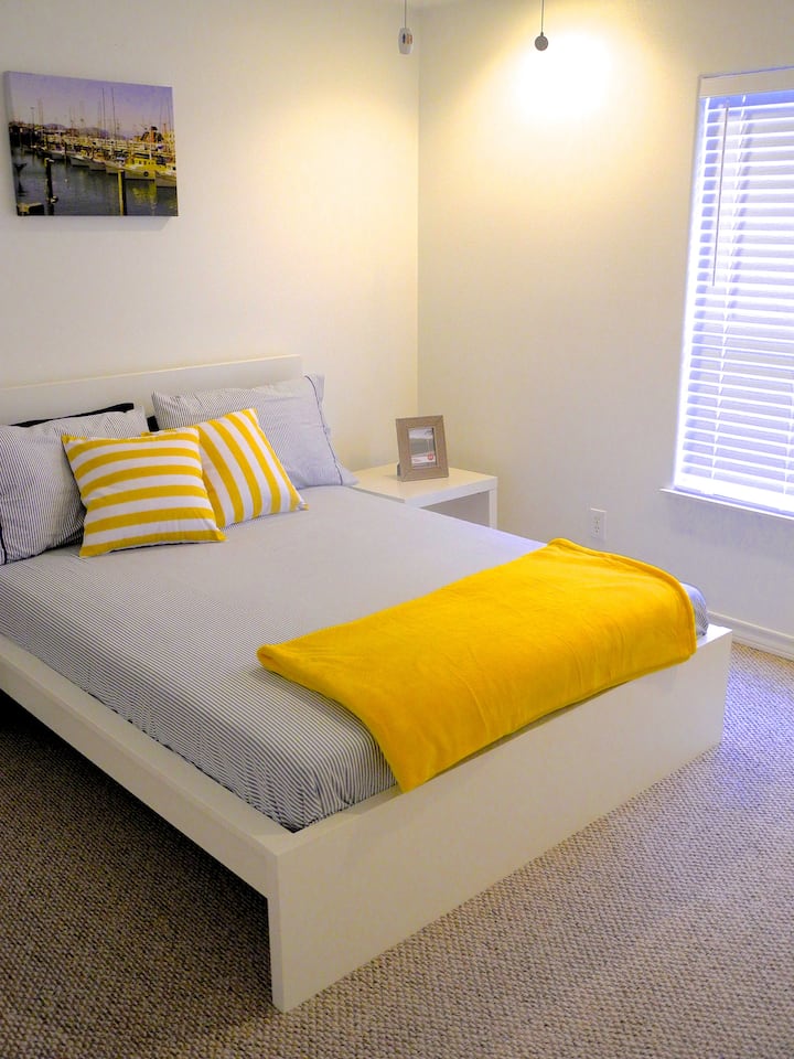 Primera habitación con cama tamaño queen y puerta al baño de invitados.