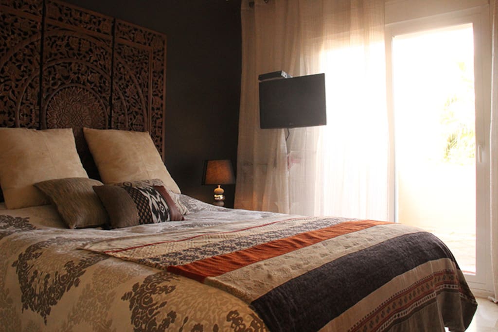 Queen-size-bed with T.V. and sliding door to the balcony