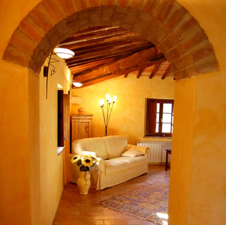 סלון בקומה הראשונה של הווילה עם חלונות וקמין, קורות עץ גדולות וקשתות עתיקות