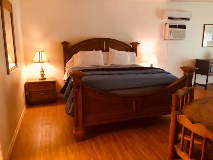 Cómoda cama tamaño king en una espaciosa cabaña para huéspedes