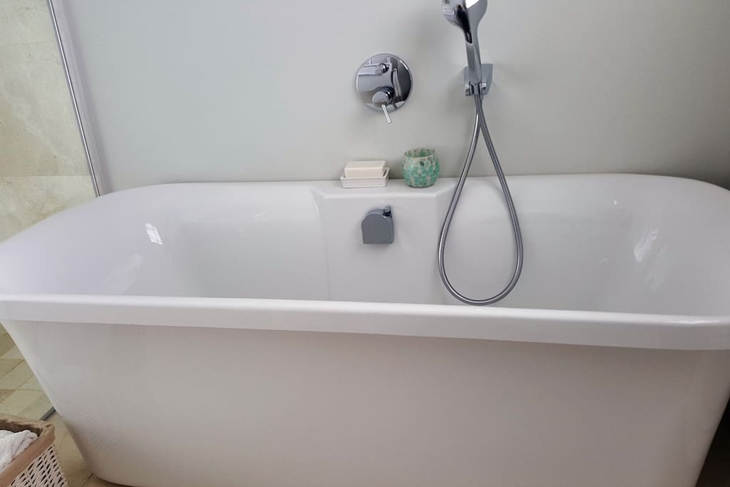 The bathroom has a free standing bath and shower