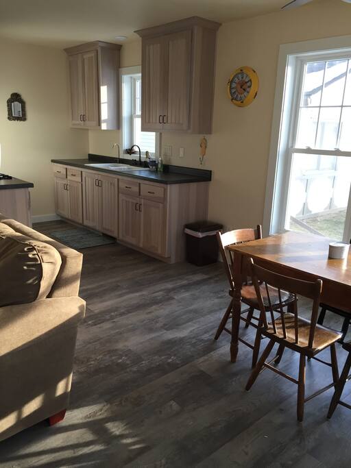 Here is the kitchen with a microwave, refrigerator, stove and coffeepot. There are lots of windows with a view.