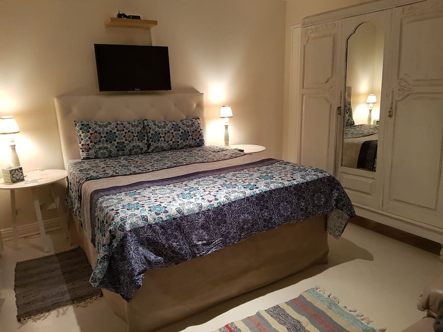 Bedroom consists of double bed with old fashioned wardrobe. The wardrobe serves as a divider between the bathroom and bedroom.