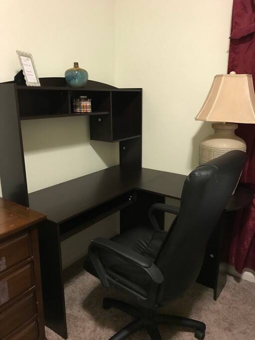 Work space with computer table and comfy leather chair.