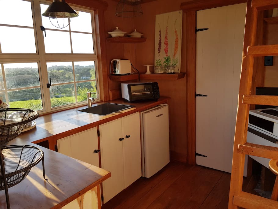 Lovely rimu kitchen with bathroom thru white door with shower and hand basin.....loft up the ladder and can sleep another adult....