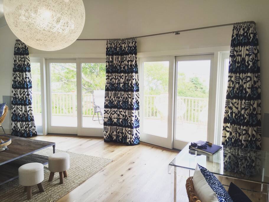 Upper level living room opens to wrap around porch for lounging, dining and BBQ-ing.