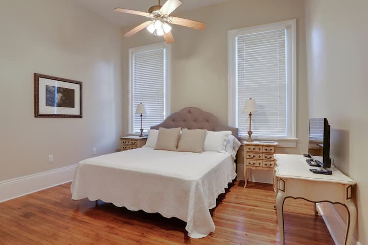 غرفة نوم بسرير كبير مع تلفزيون بشاشة مسطحة وخزانات كبيرة.