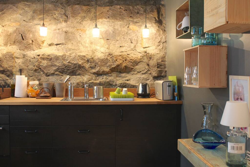 Kitchen with induction hob, microwave, fridge with small freezer