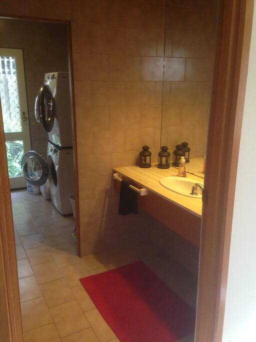 Adjacent sink, bathroom and shower, with laundry facilities