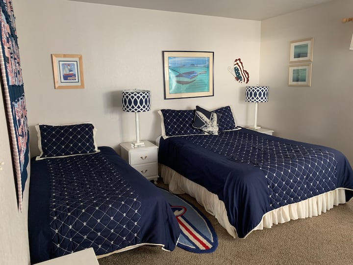 ห้องนอนผู้เข้าพักชั้นบนพร้อมเตียงเดี่ยว 1 เตียงและเตียงควีนไซส์ 1 เตียงดาดฟ้าส่วนตัว