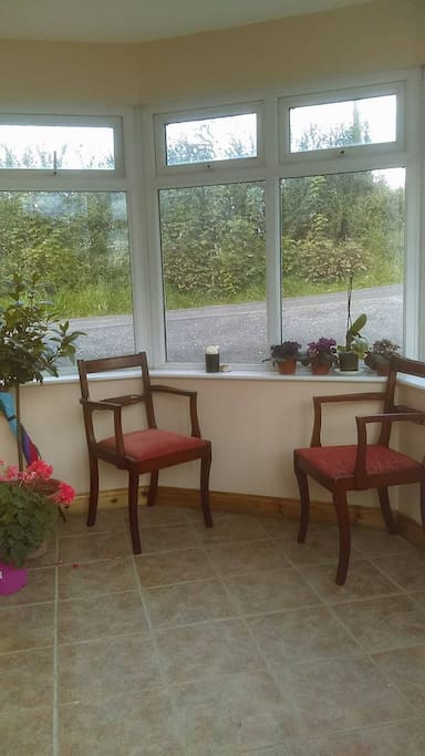 Glassed porch provides separate guest entrance and smoking area.