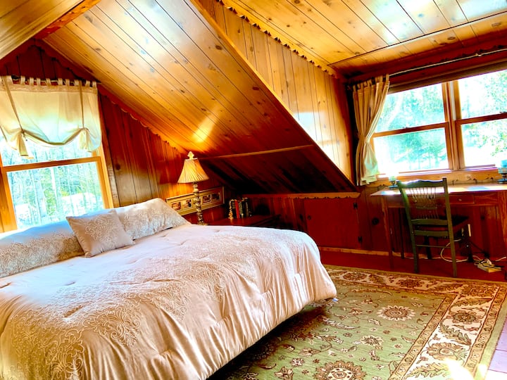 楼上的加大双人床卧室配有第三台电视，所有窗户外都有美丽的木景。