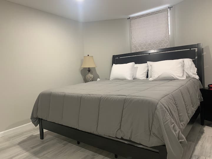 Deze kingsize slaapkamer bevindt zich in de kelder en heeft een zitstoel en smart-tv.