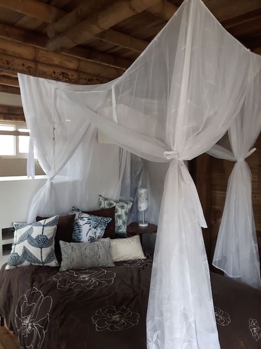 Super comfy bed with full length mosquito net and lots of pillows and white quality sheets.