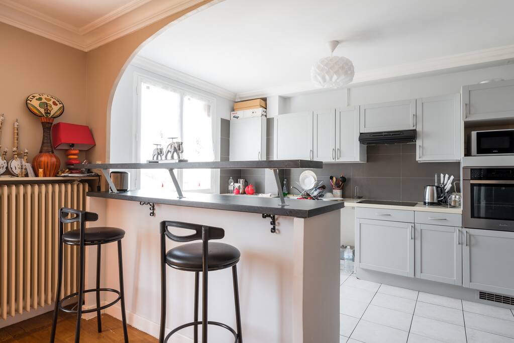 Petit bar avec 4 tabourets faisant le lien entre la cuisine et le salon.