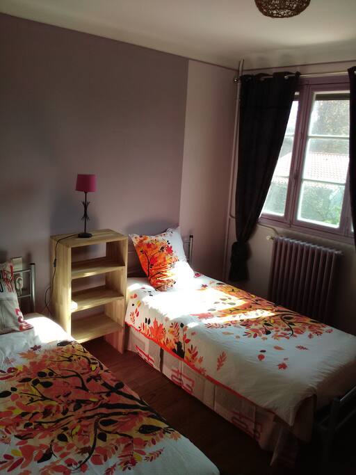 Chambre deux lits donnant sur jardin.