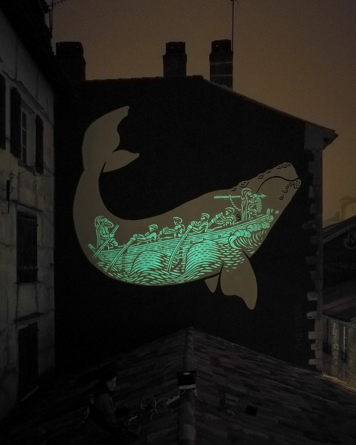A vibrant phosphorescent mural of a whale is featured prominently on the dark wall. The artwork depicts a whimsical scene with figures riding on the whale's back, creating a lively contrast against the muted cityscape in the background.