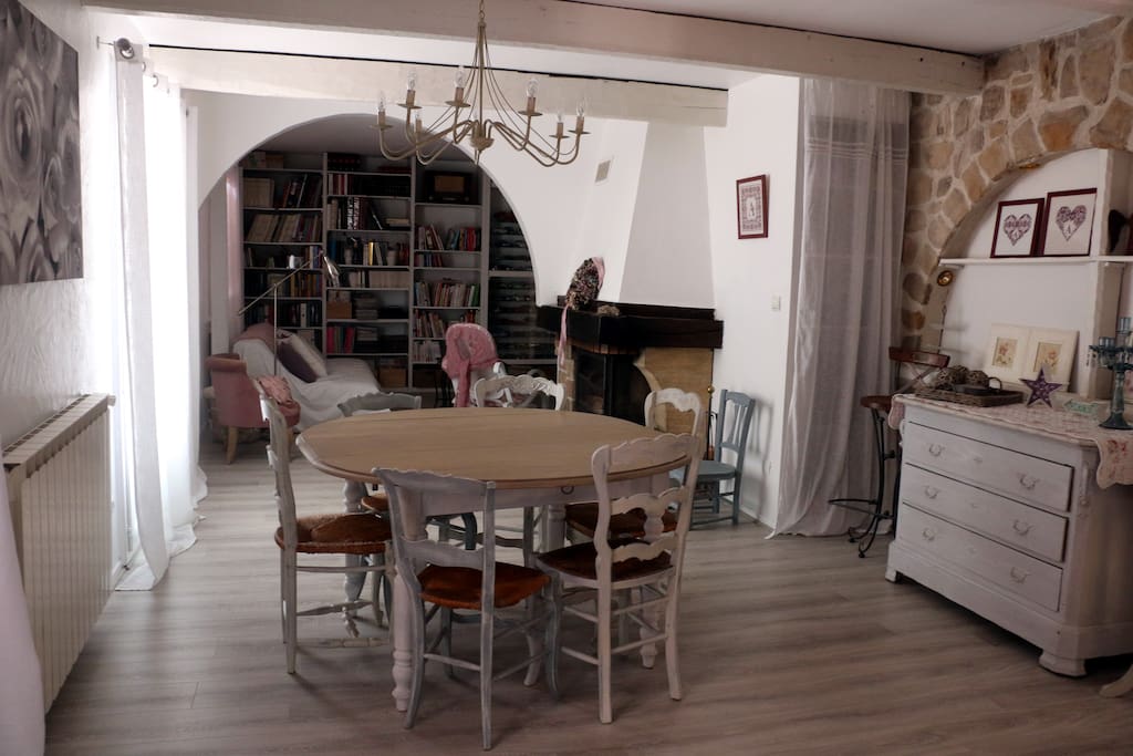 Pièce à vivre. Salon, salle à manger de 40m2. Vue sur la piscine et le jardin. Parquet et mur en pierres.
