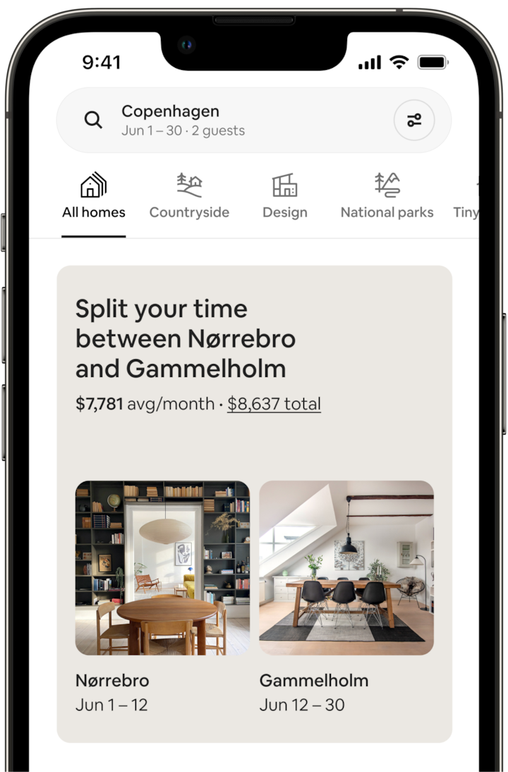 The screen of a mobile phone shows a Split Stay. The screen says: “Split your time between Norrebro and Gammelholm” and displays the price for the trip. Below, there are two photos of the homes. The Norrebro image shows a dining room with a large charcoal bookcase and a modern chandelier. The Gammelholm image shows another dining room, this one lit by a large skylight. Each photo is captioned with dates, which make clear that the guest would spend 12 days in Norrebro, followed by 18 days days in the Gammelhorm home.