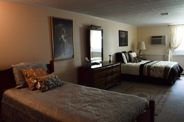 Bedroom showing single and double beds with dresser. Room has wall-to-wall closet and highboy drawer chest