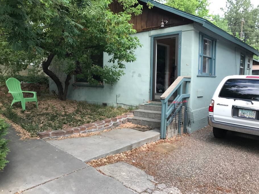 Front of house with parking for two cars in driveway. There are two houses on the property. The other house, the back house, is occupied.