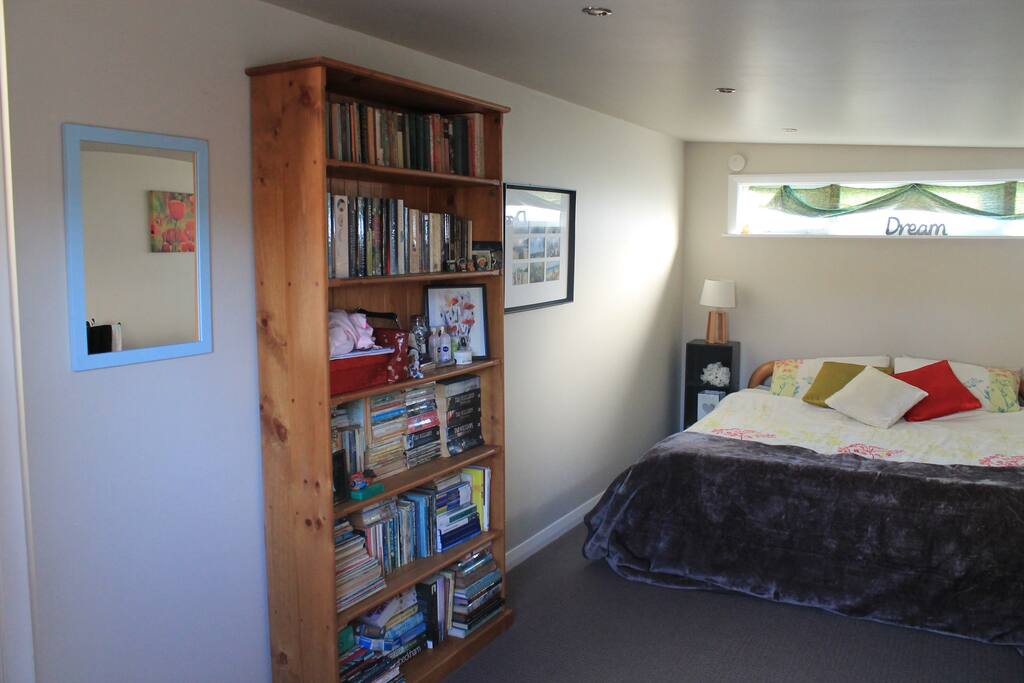 Mirror, shelf, books all in the room.