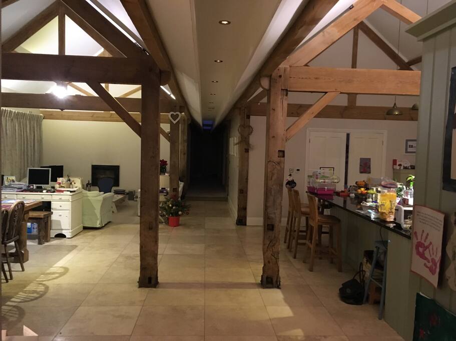 Open plan living space with dining area to left and kitchen to right with playroom double doors in front of the kitchen.
