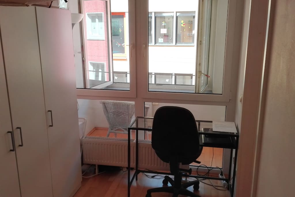 Schreibtisch im Schlafzimmer mit Kleiderschrank, Ausblick auf Loggia
