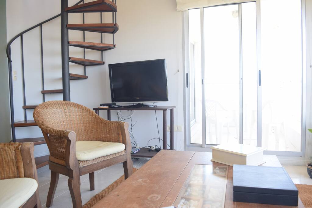 Living room y escalera de aceso al piso superior
