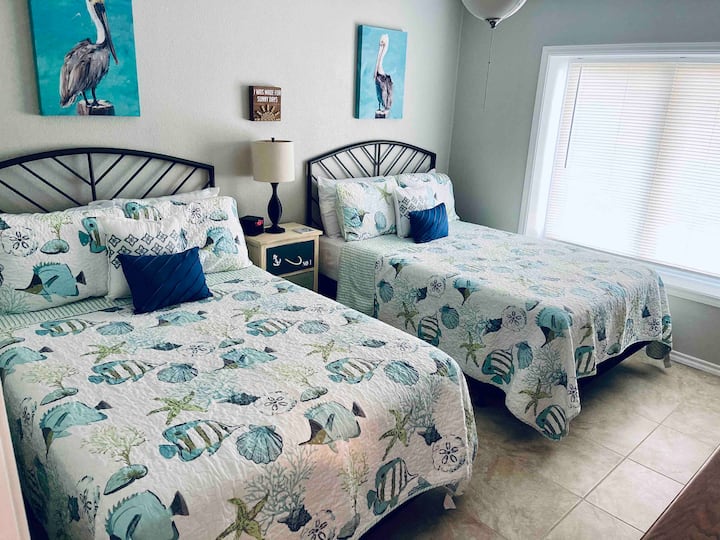 Second bedroom with two full beds, large tv, and ensuite bathroom. 